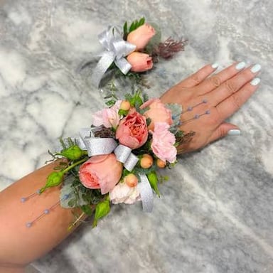 A wrist corsage and a boutonniere, showing two floral accessories worn at formal events.