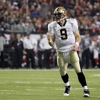 A football quarterback celebrating after throwing a touchdown pass.