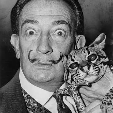 Salvador Dalí pictured with Babou, the ocelot he kept as a pet.