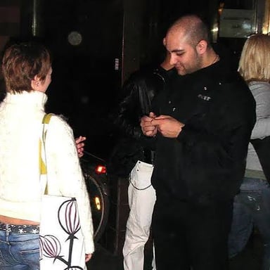 A venue bouncer escorting a patron toward the exit