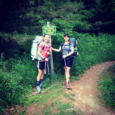 Hikers walking along a mountain trail on a long trek.