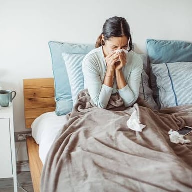 A person resting in bed while recovering from an illness