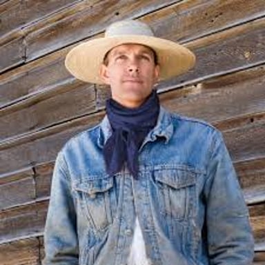 A cowboy wearing a cloth bandanna around the neck.
