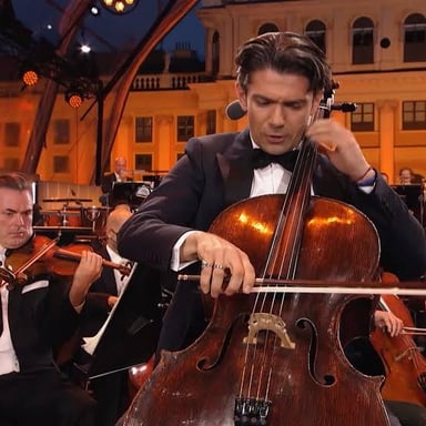 Cellists sit with their instruments upright between their knees as they play.