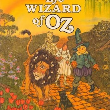 An illustration of the Wizard of Oz revealed behind a screen to Dorothy and her companions.