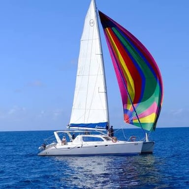 A sailboat moving over the water with its sails filled.