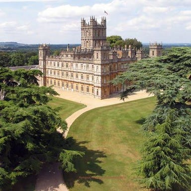 A historic manor house surrounded by its grounds.