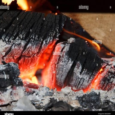 Red embers glowing as they smolder without open flames.