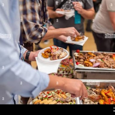 A diner loading food onto a plate at a buffet.