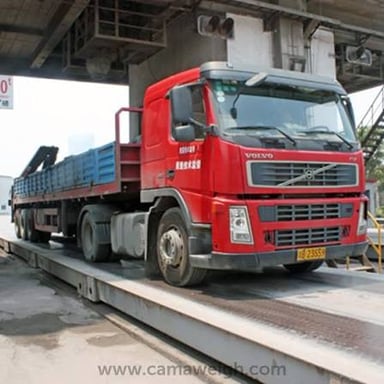 A freight truck on a weighbridge, illustrating a measure of cargo weight.