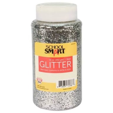 Shiny glitter flakes scattered across a piece of colorful craft paper.