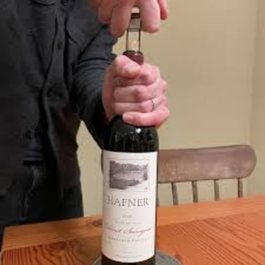 A cork being pulled from a bottle of Cabernet Sauvignon
