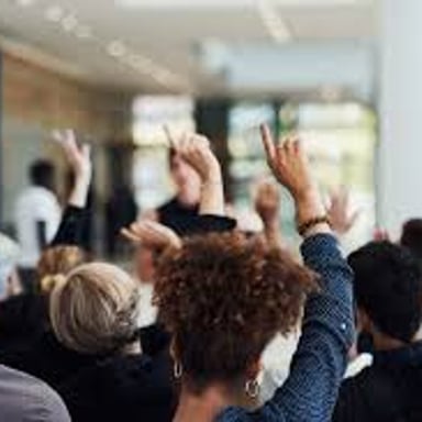 A group voting by raising hands in opposition to a proposal