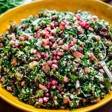 A bowl of tabbouleh, a parsley-forward Levantine salad with bulgur and tomato.