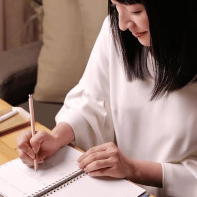 A person writing down a goal in a notebook.