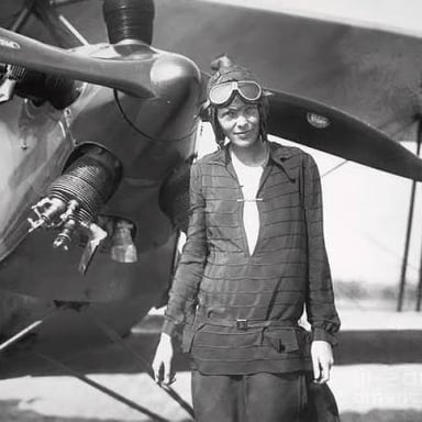 Amelia Earhart, the pioneering American aviator, pictured beside an airplane.