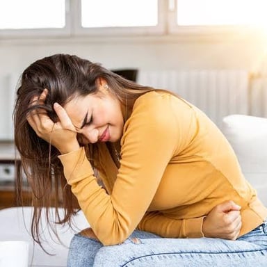 A person holding their stomach, suggesting the queasy discomfort associated with stress.