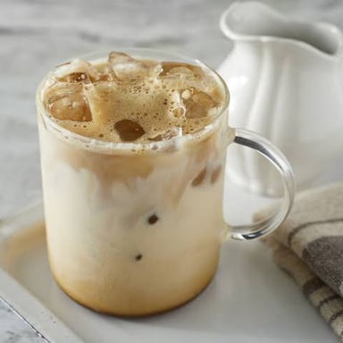 A glass of iced coffee with visible ice cubes.