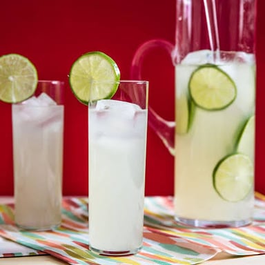 Glasses of pale citrus drinks garnished with lemon and lime