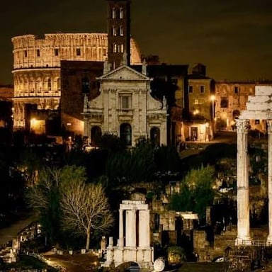 Historic buildings in Rome are illuminated after dark.