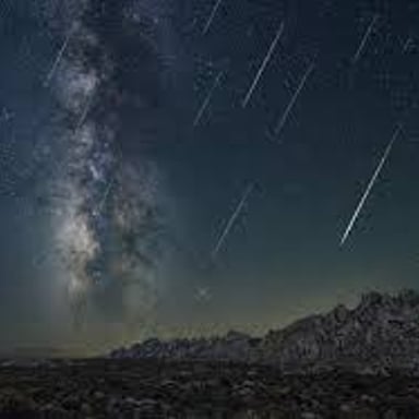 Bright meteors from the Perseid shower streaking across a night sky