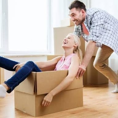 A person carrying boxes while moving to a new home.
