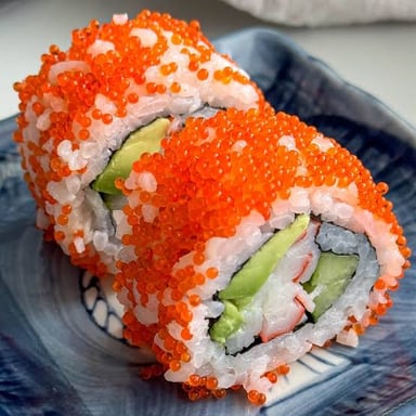 Sushi topped with small orange beads of fish roe.