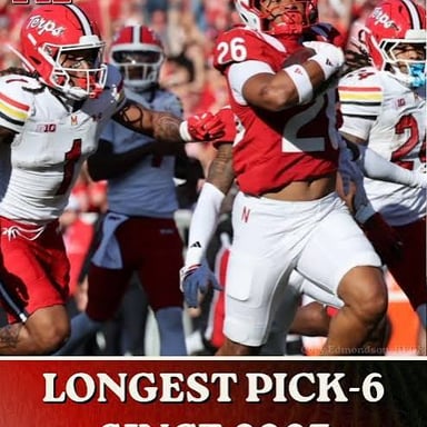 A defensive player intercepts a pass and runs with the ball toward the end zone.