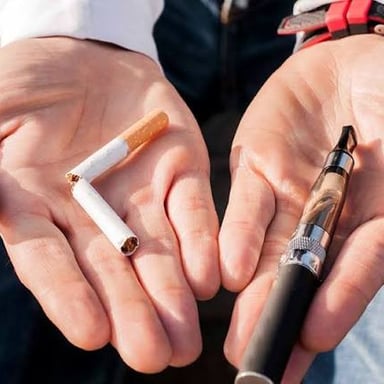 An electronic cigarette beside a conventional cigarette