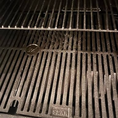 Gray ash left beneath a grill after charcoal or wood has burned.
