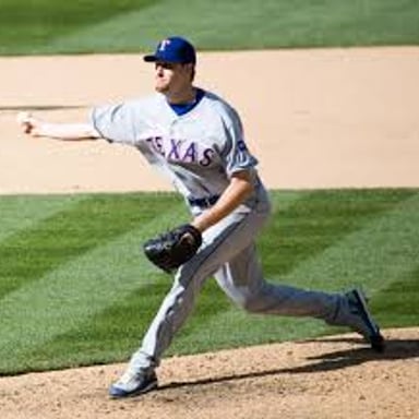 A pitcher releases a baseball with the arm swinging low and sideways.