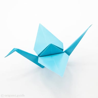 A folded-paper origami crane with its wings outstretched.
