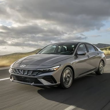 A compact four-door sedan, a small passenger car with a separate trunk.