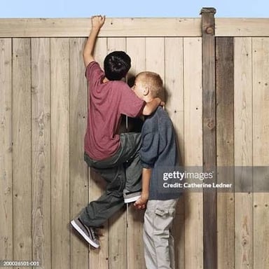 One person helping another climb by providing a leg up.