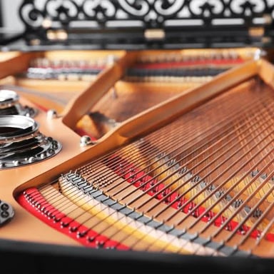 A grand piano with its open lid exposing the soundboard and strings.