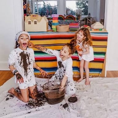 Children play noisily among toys scattered across a room.