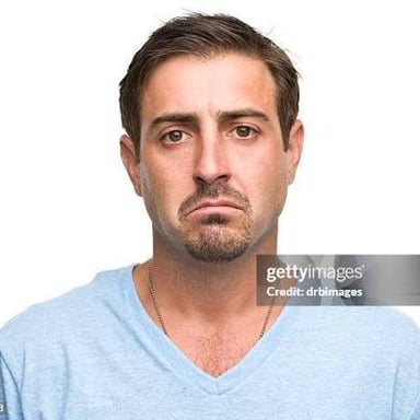 A person frowns with a grumpy expression.