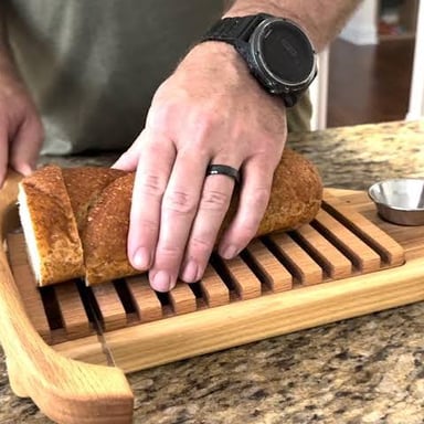 Small bread crumbs scattered across a wooden breadboard.