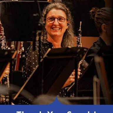 A musician playing an oboe in an orchestra.