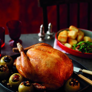 A roast turkey surrounded by traditional Thanksgiving side dishes
