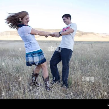 A person turning around in an open field.
