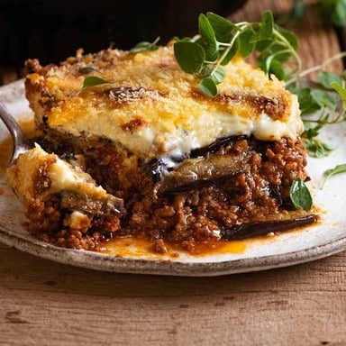 Slices of eggplant layered in a dish of Greek moussaka.