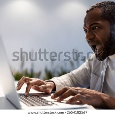A person typing at a laptop, illustrating an angry online comment.
