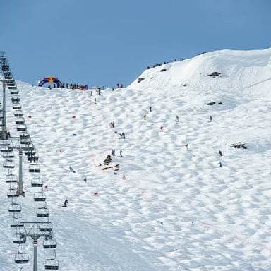 A skier moving over rounded bumps on a snowy slope.