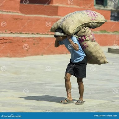 A person carrying a heavy load across their shoulders.