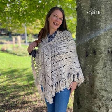 A crocheted shawl draped over a person’s shoulders.