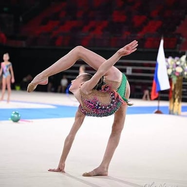 A gymnast bends into a deep stretch.