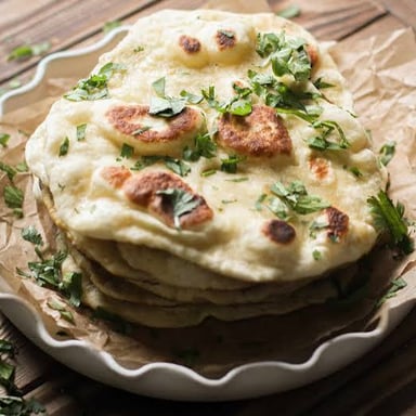 A piece of naan, a soft Indian flatbread.