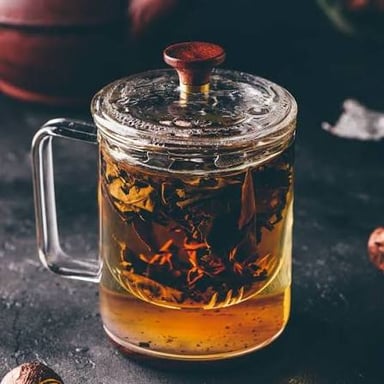 Tea leaves steeping in hot water in a teapot.