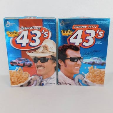 A bowl of ring-shaped Cheerios cereal beside its box.